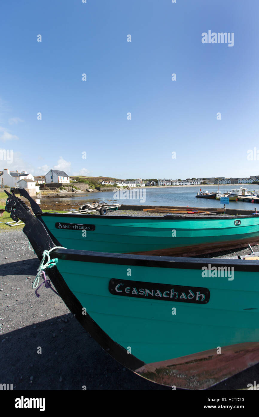 Isle of Islay, Schottland. Malerische Aussicht auf zwei St Ayles Ruderboote Ruderboote am Port Ellen Waterfront und Hafen. Stockfoto