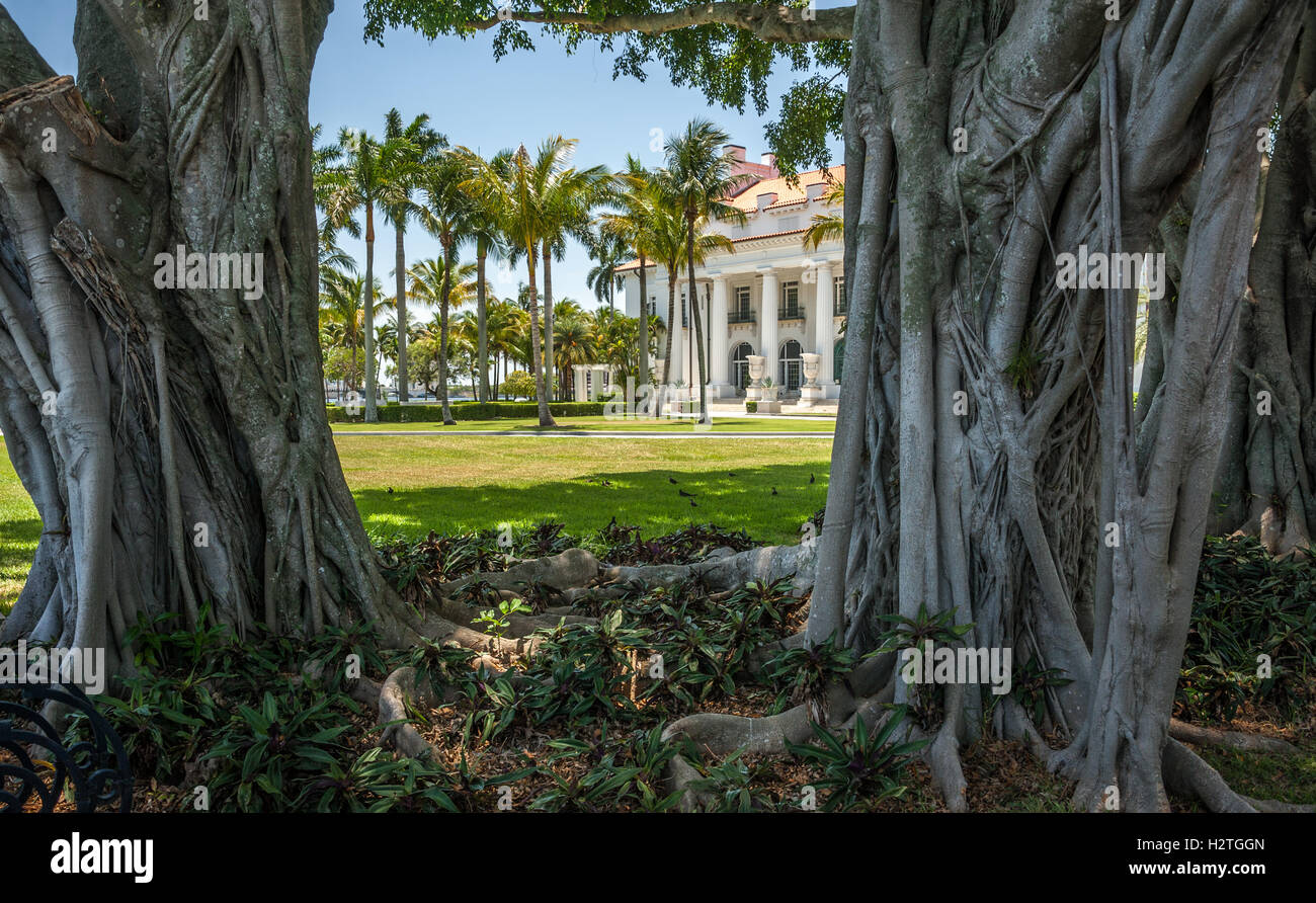 Flagler Museum, die ehemalige Palm Beach, Florida Villa des Ölmagnaten Henry Morrison Flagler, wie zwischen alten Banyan-Bäume zu sehen. Stockfoto