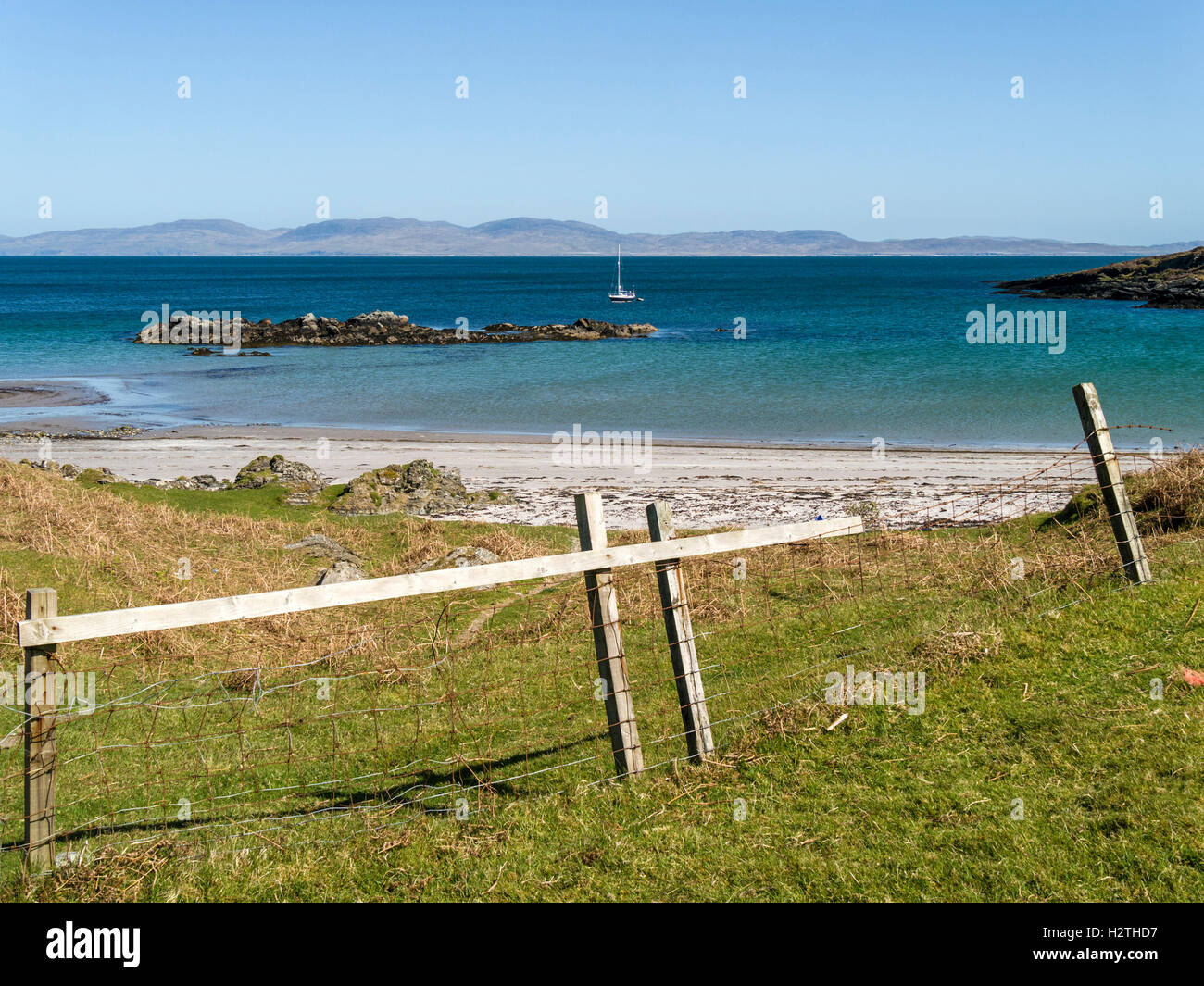 Queens Bay Beach, Insel Colonsay, mit Yacht, Loch Staosnaig und Isle of Jura jenseits, Schottland, Großbritannien. Stockfoto