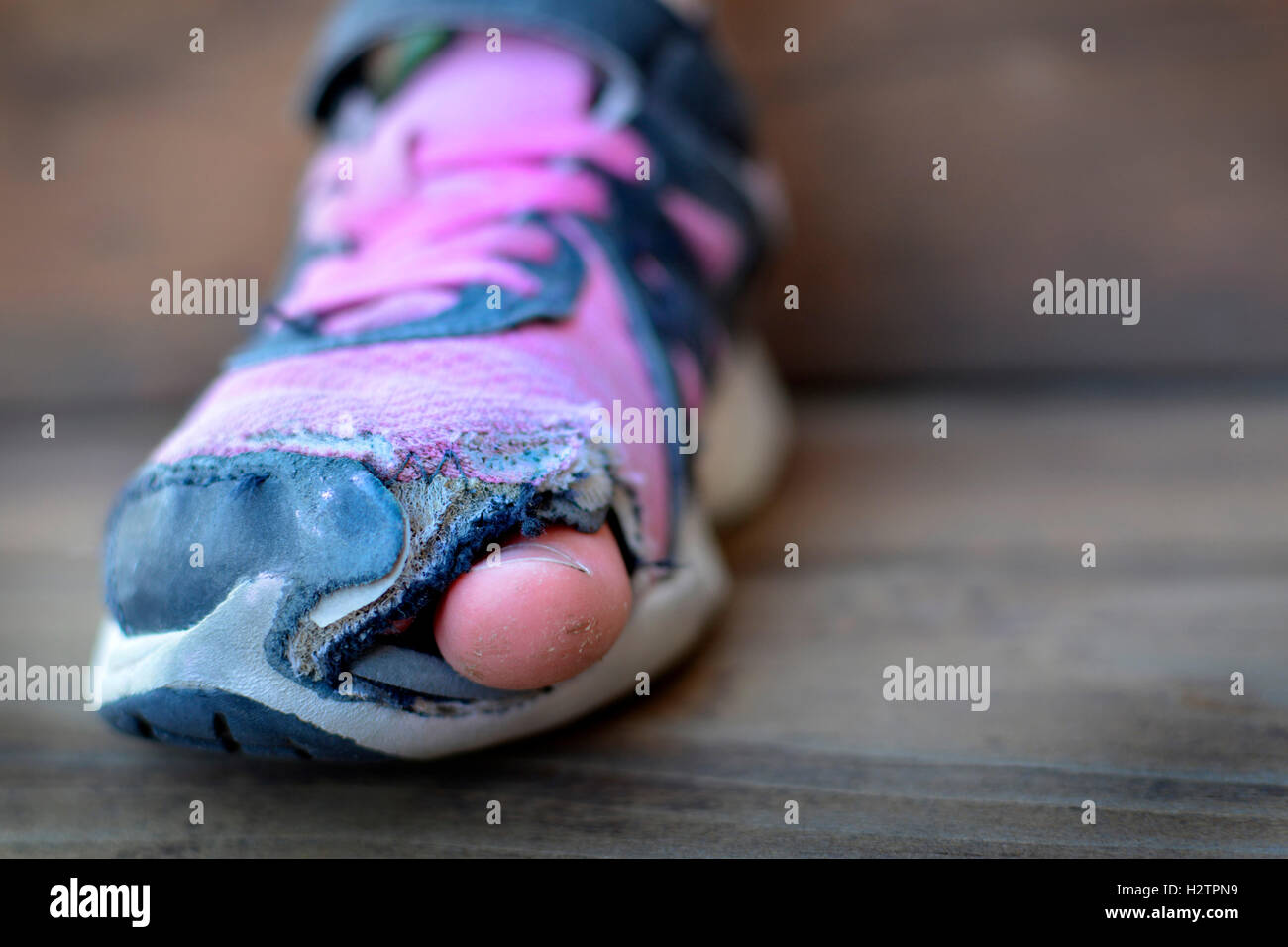Alte Schuhe mit Löchern abgenutzt schäbig für Obdachlose Kleidung Zehen ragen Stockfoto