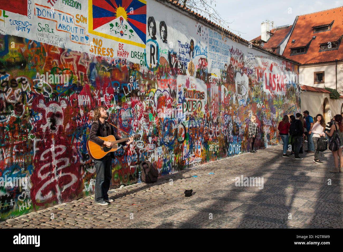 Straßenmusikant an der John-Lennon-Mauer in Prag. Nach seiner Ermordung im Jahr 1980 war es eine politische Graffiti Protest von der junge Tscheche Stockfoto
