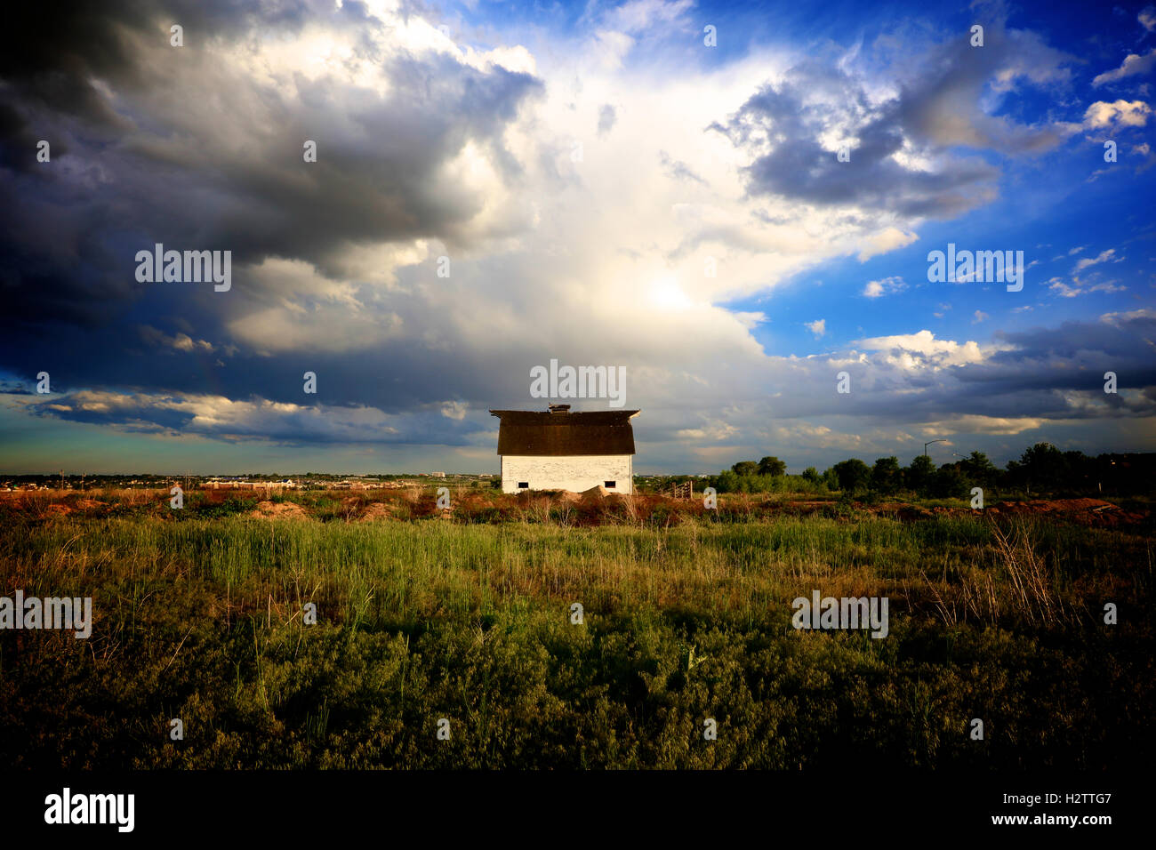 Altes weißes Haus in Prärie Wiese mit Sturm im Hintergrund Stockfoto