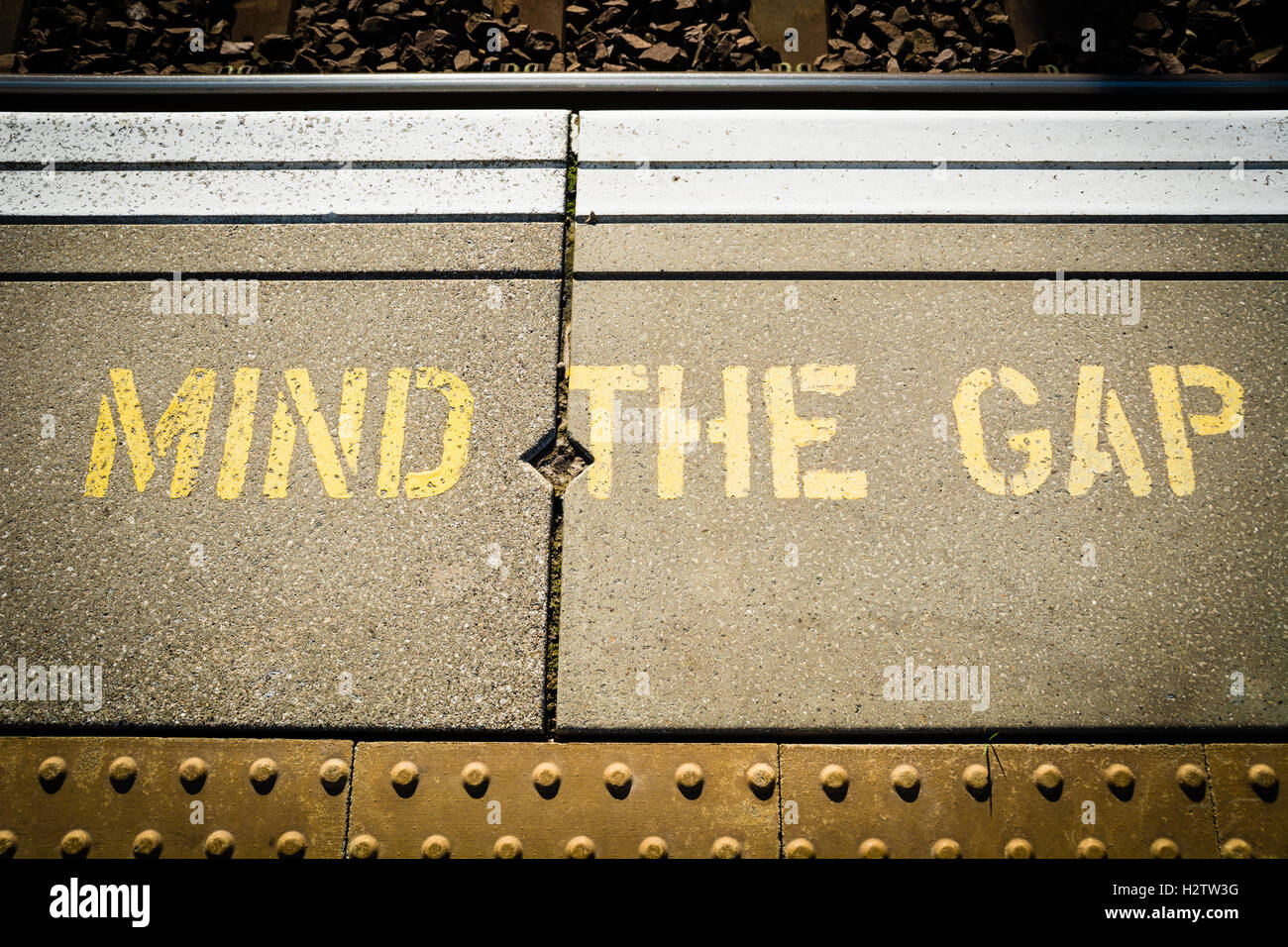 "Mind the Gap" gelber Schrift Zeichen auf einem Bahnsteig Stockfoto