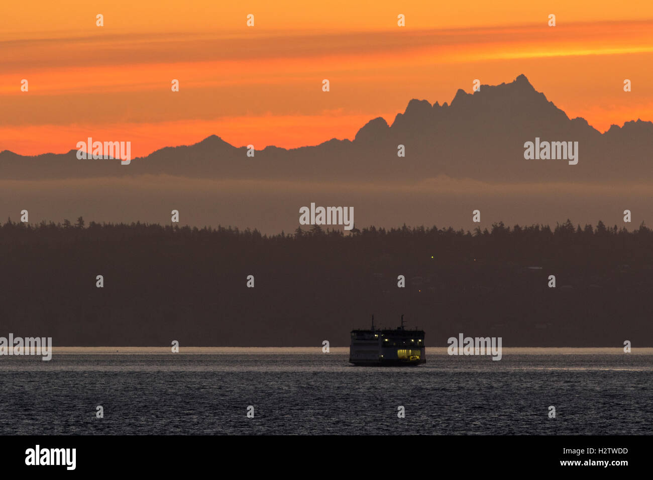 Puget Sound ferry bei Sonnenaufgang mit Cascade Mountains im Hintergrund. Washington State ferries. Stockfoto