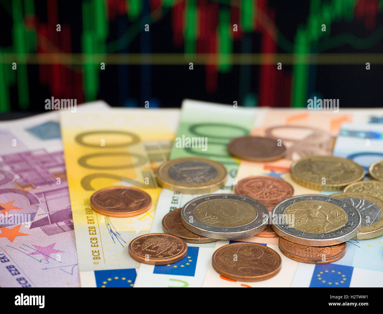 Euro-Banknoten und Münzen auf den Diagrammhintergrund Stockfoto
