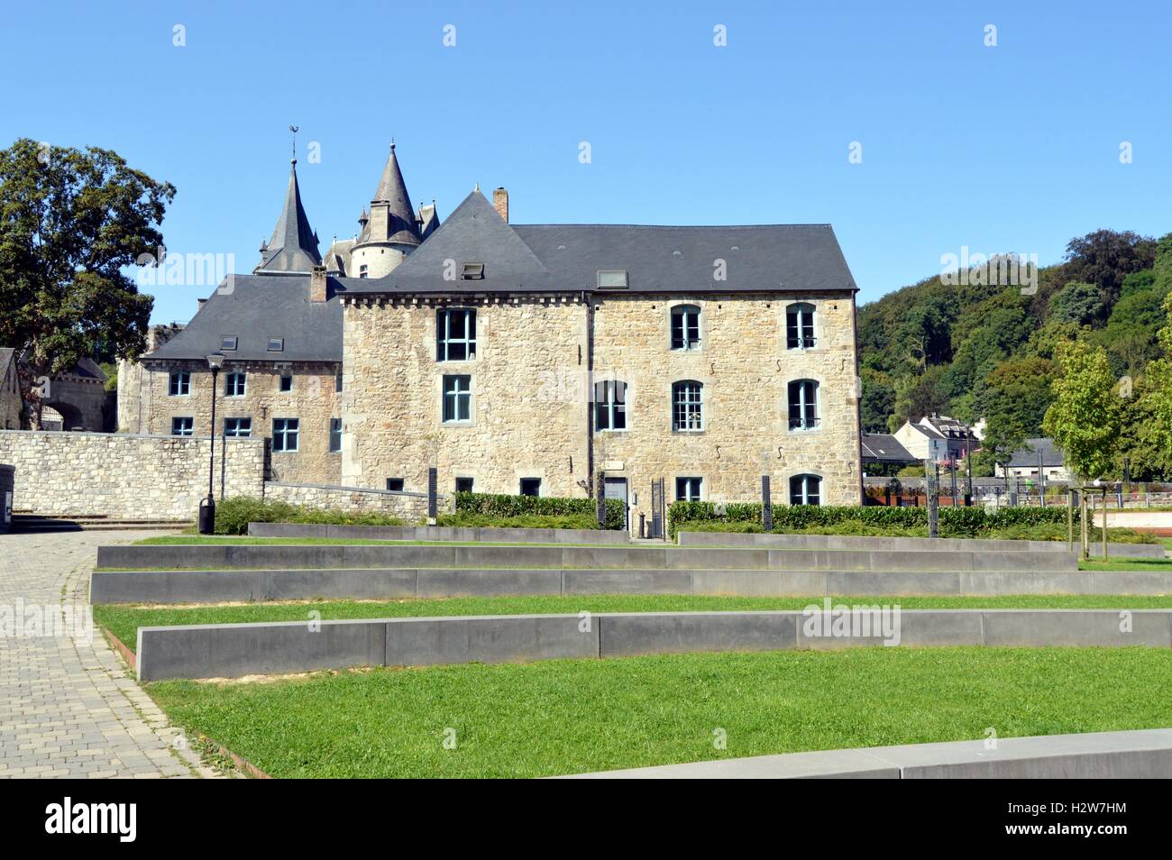 Ehemalige Burg im Wald mit einem Weg von Bäumen und eine große Liegewiese. Stockfoto