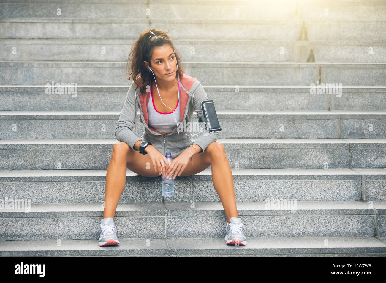 Fitness-Frau eine Pause vom laufen auf Stufen. Stockfoto