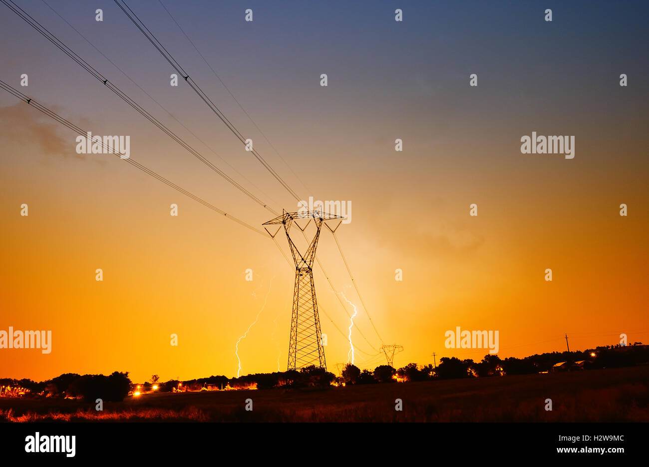 Hochspannungs-Pylon mit dem Blitz am Himmel in der Nacht Stockfoto