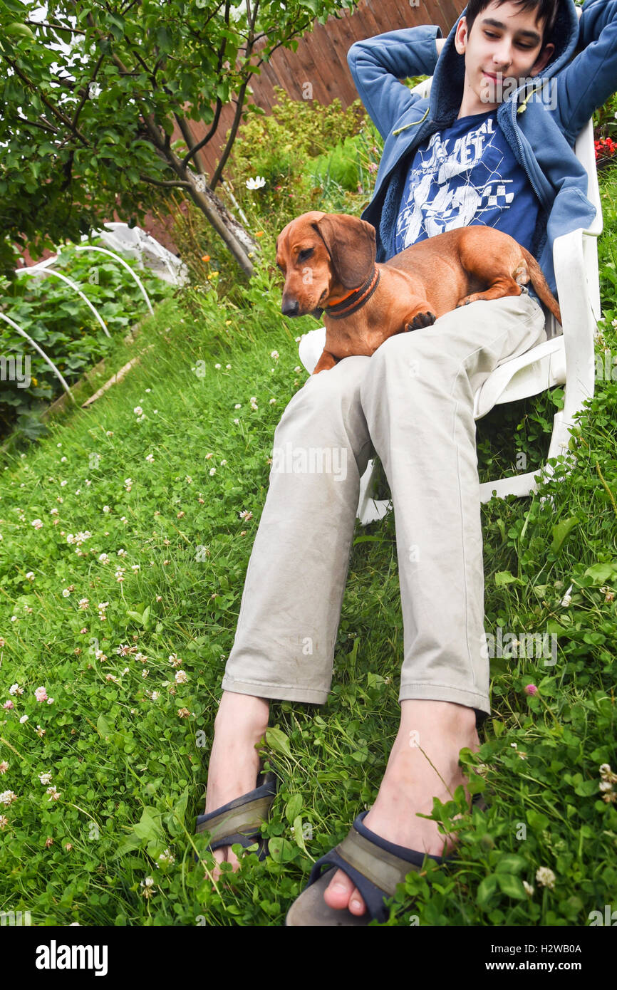 Junge mit einem Hund im Garten Stockfoto