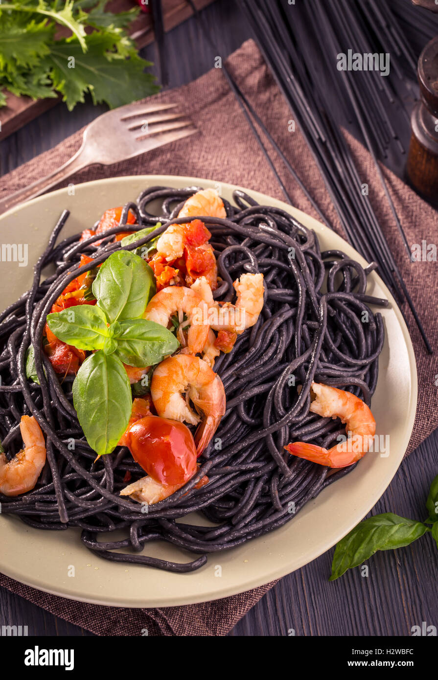 Schwarze Spaghetti mit Garnelen und Basilikum Stockfoto