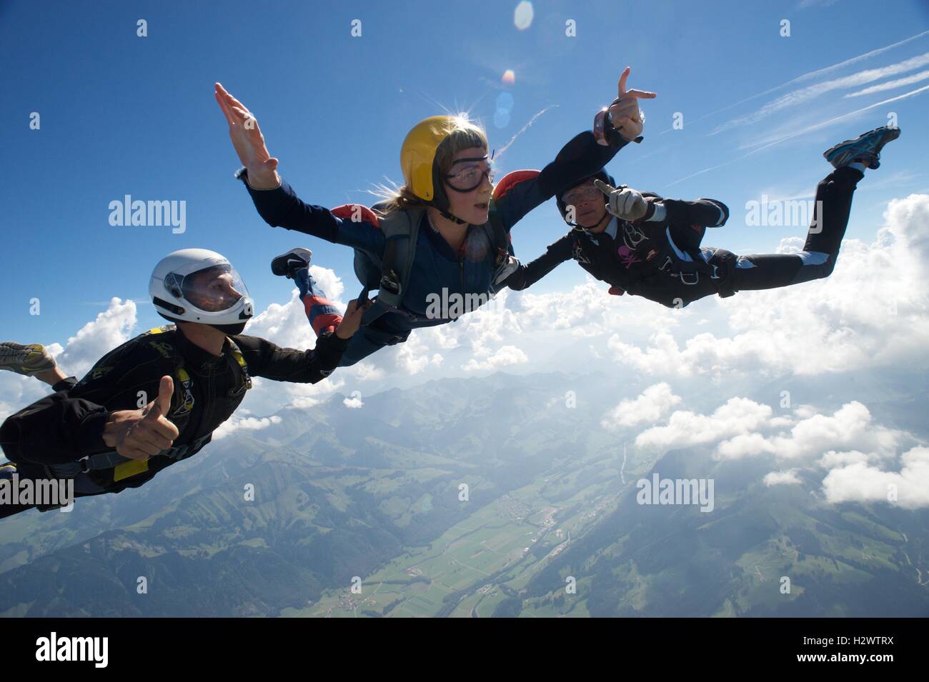 Frau auf ihrem ersten Freifall-Sprung mit zwei Lehrern Stockfoto