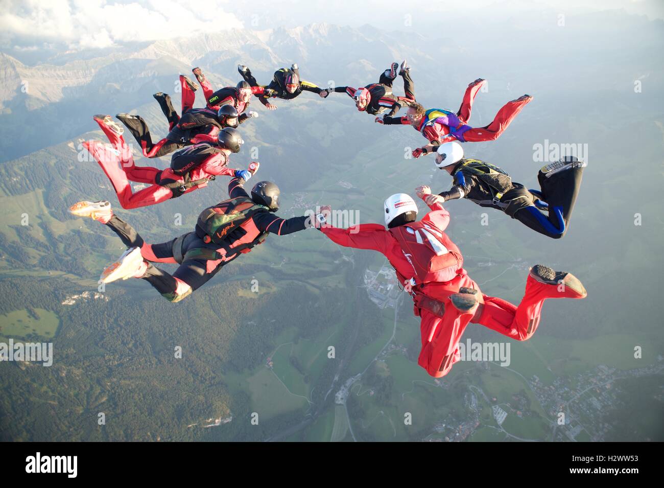Neun Fallschirmspringer bilden eine Sternentstehung über Gruyères in der Schweiz Stockfoto
