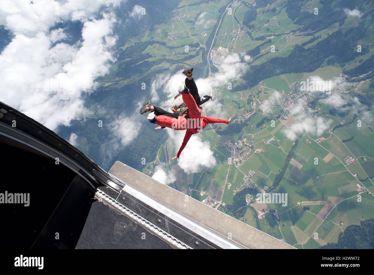 Tandem-Master übernimmt Frau auf ihrem ersten Fallschirmsprung Gruyeres in der Schweiz. Stockfoto