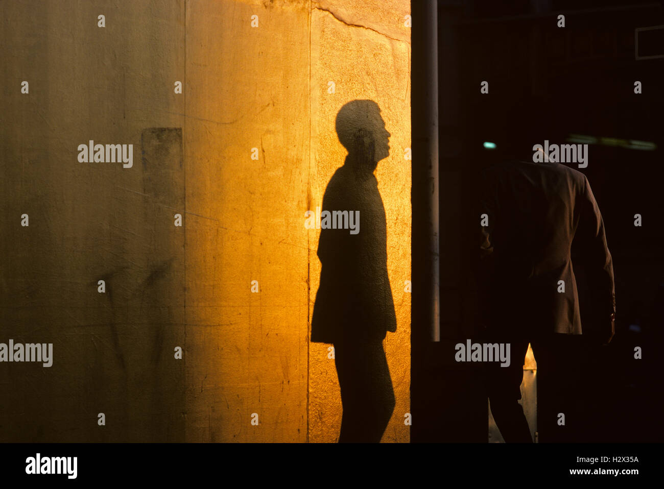 Silhouette Mann entlang Downtown Straße am Sonnenuntergang Schatten auf drehen Wandecke Straße Seattle Washington State USA überqueren Stockfoto
