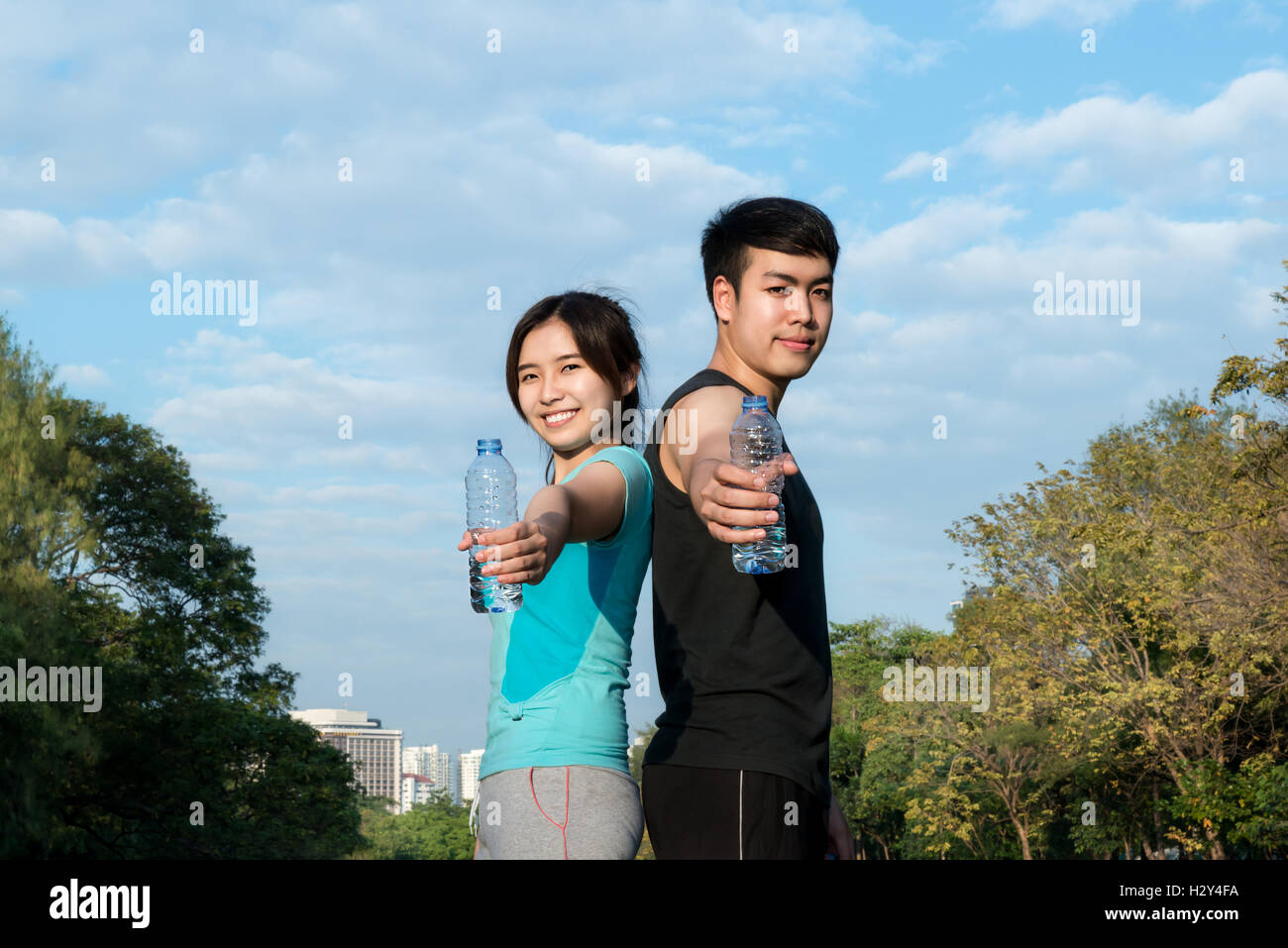 Asiatische junge Mann und Frau Trinkwasser aus Wasserflasche nach Fitness Sport trainieren Sie im Park. Stockfoto