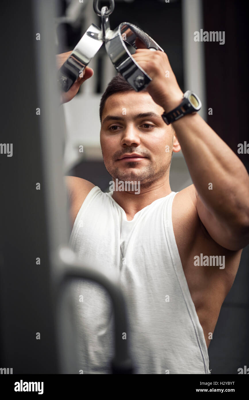 Gut aussehende sportlicher Mann training auf einem Fitness-Studio-Apparat Stockfoto
