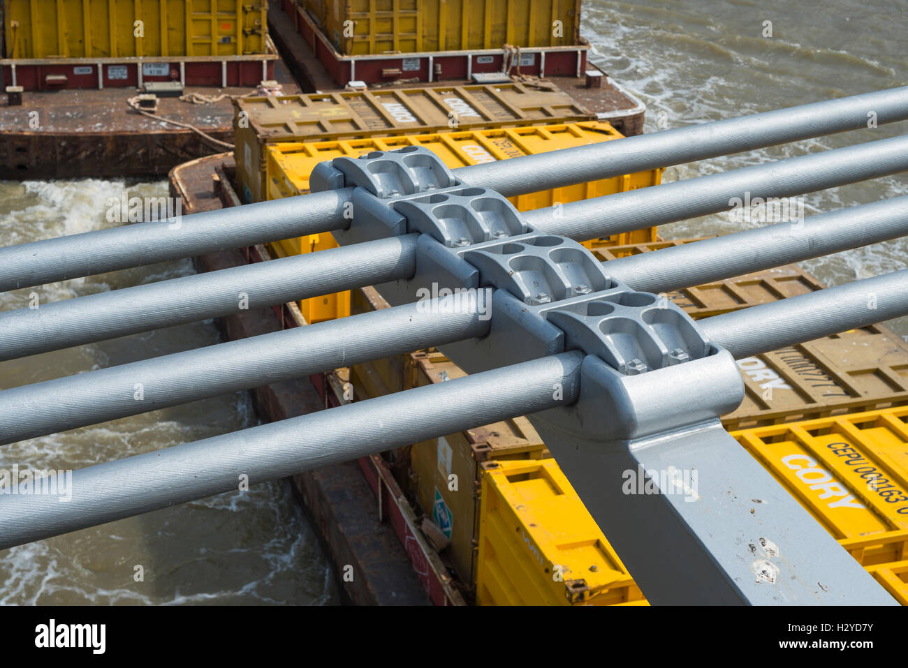 Cory Abfallbehälter auf einem Boot unter einem Kabel Federelementes und Fluid-Dämpfer von der Millennium Bridge über die Themse, London, UK Stockfoto