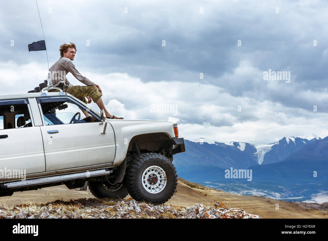 Mann sitzt auf dem Auto SUV der Berge-Rad Stockfoto