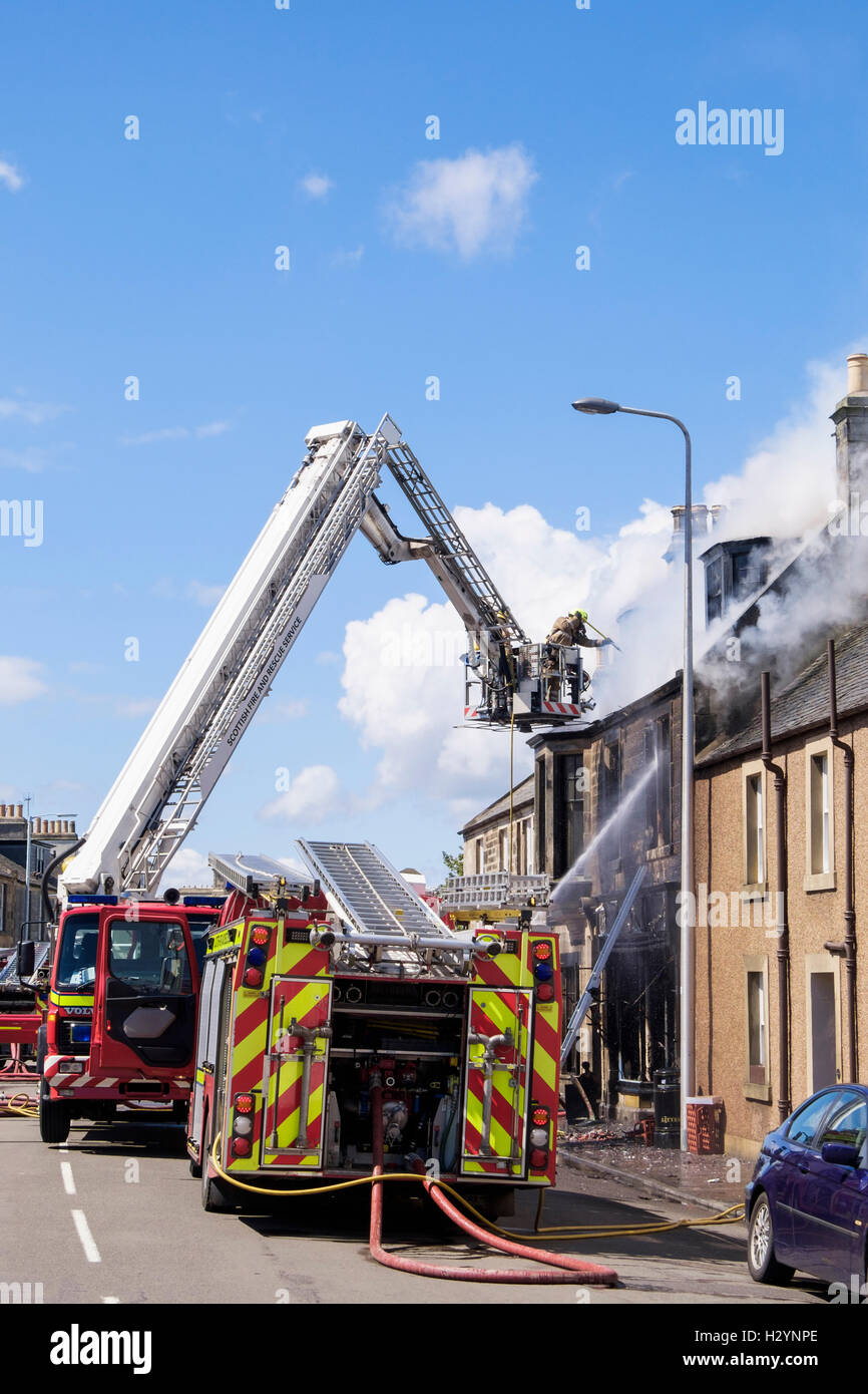 Schottische Feuerwehr Feuerwehr oben eine Leiter Bekämpfung ein brennendes Gebäude in Elie und Earlsferry, Fife, Schottland, UK Stockfoto