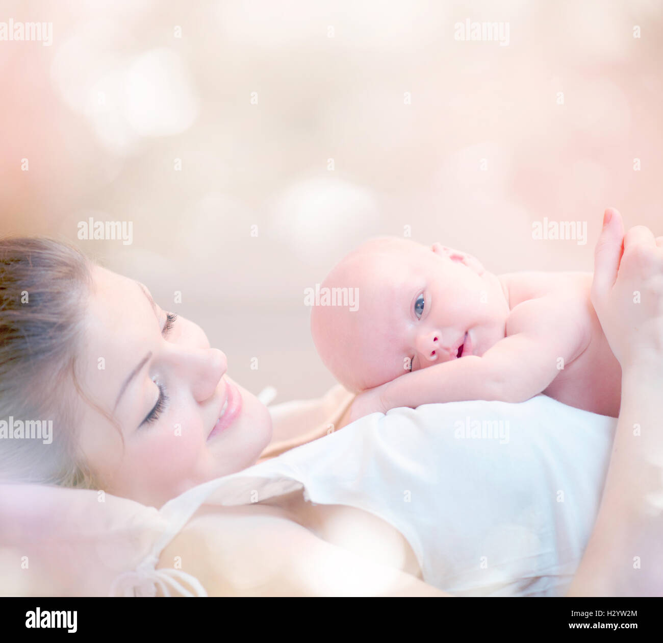 Glückliche Mutter und ihr neugeborenes Baby küssen und umarmen Stockfoto