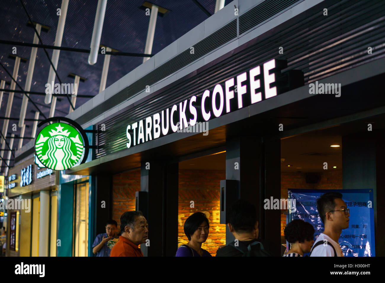 Starbucks Coffee-Shop mit Kunden in der Schlange im Flughafen Shanghai, China. Stockfoto