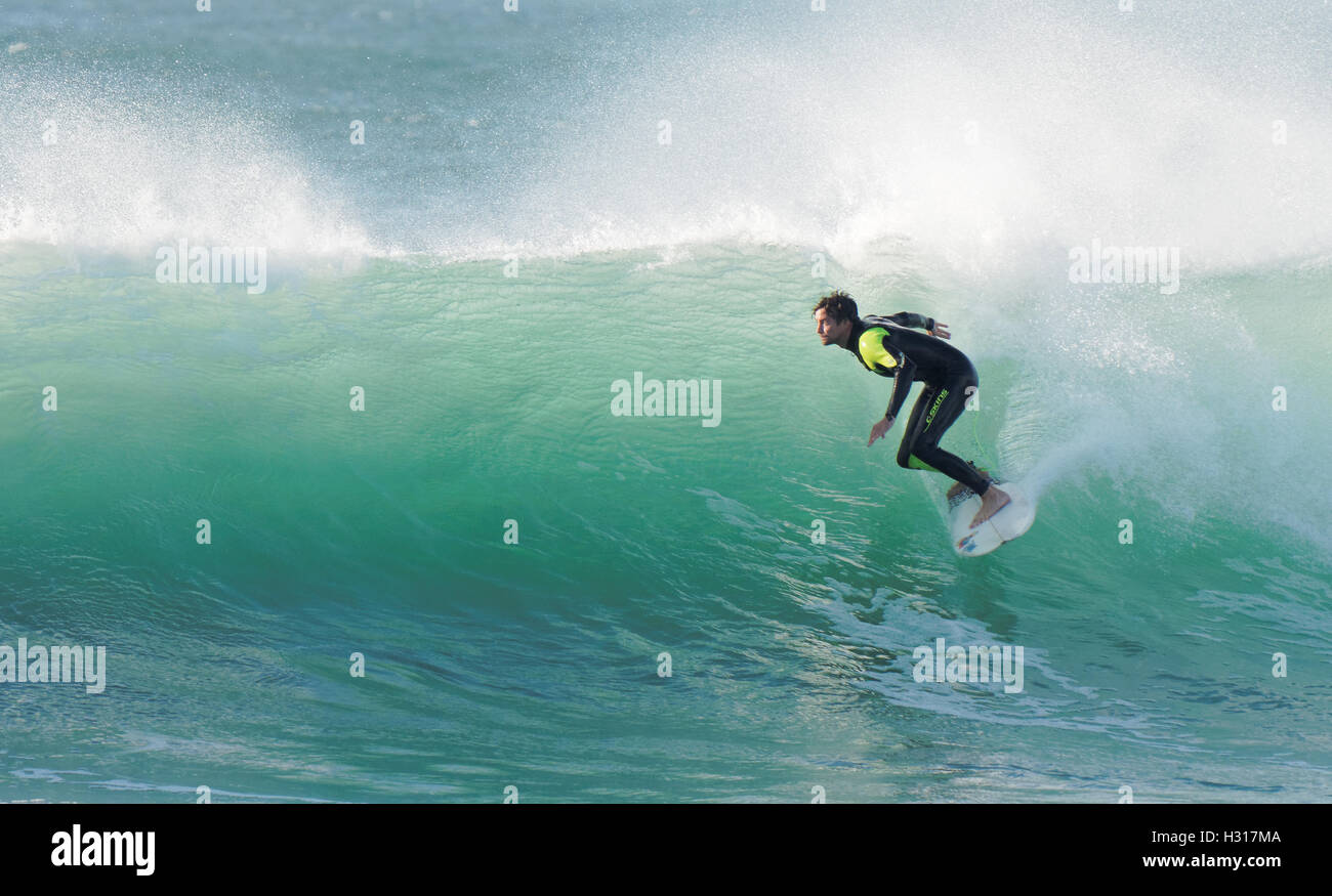 Einsamer Surfer reitet riesige beleuchtete wieder Sonnenschein Surf UK Stockfoto