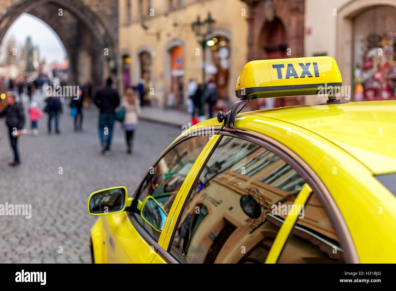 Gelbes Auto mit Taxi unterzeichnen auf dem Dach in der Altstadt von Prag, Tschechische Republik (Fokus auf dem Schild). Stockfoto