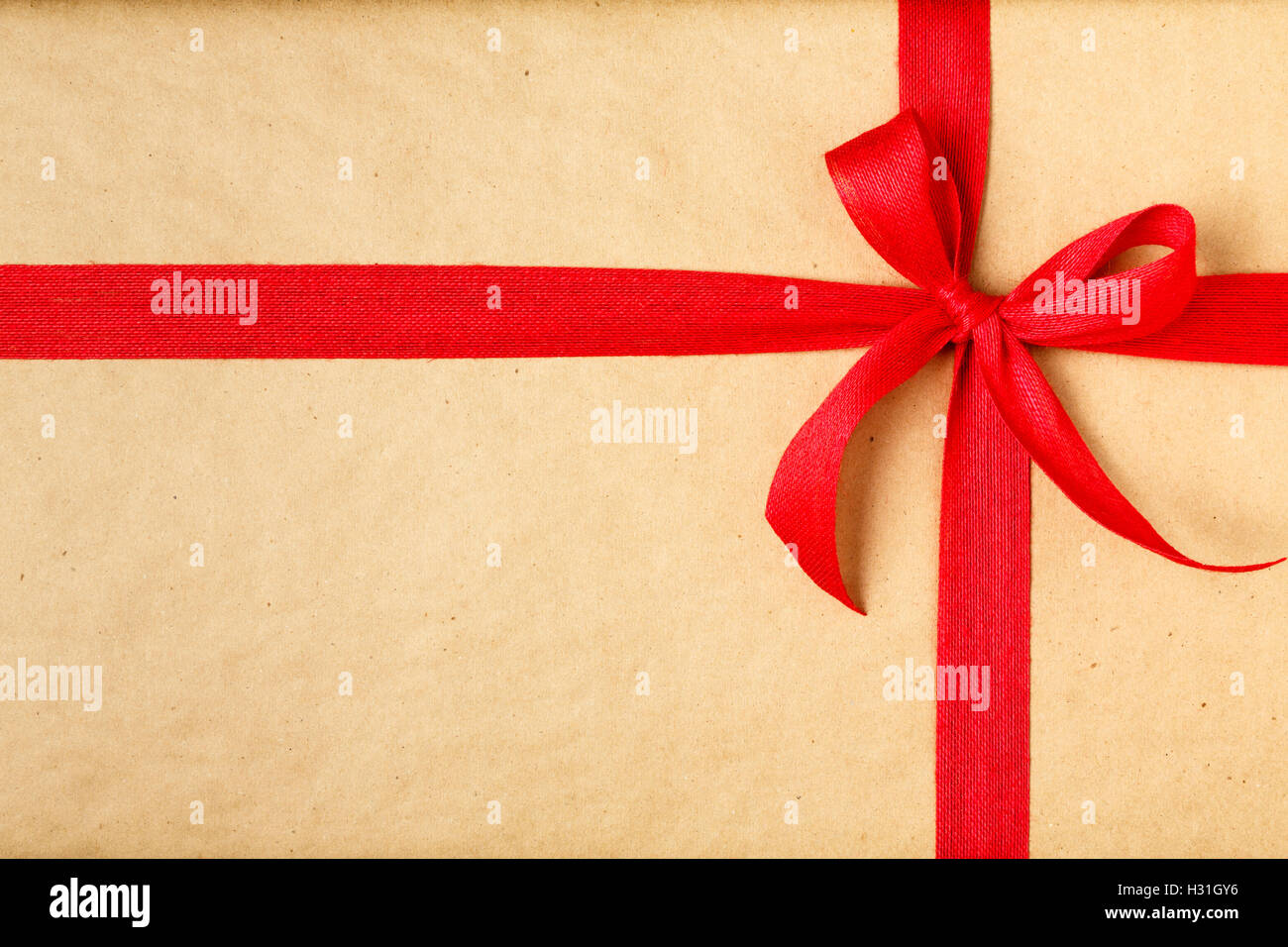 Einfache Weihnachts-Geschenk Weihnachten präsentieren Hintergrund mit recycelten Geschenkpapier und roter Schleife Stockfoto