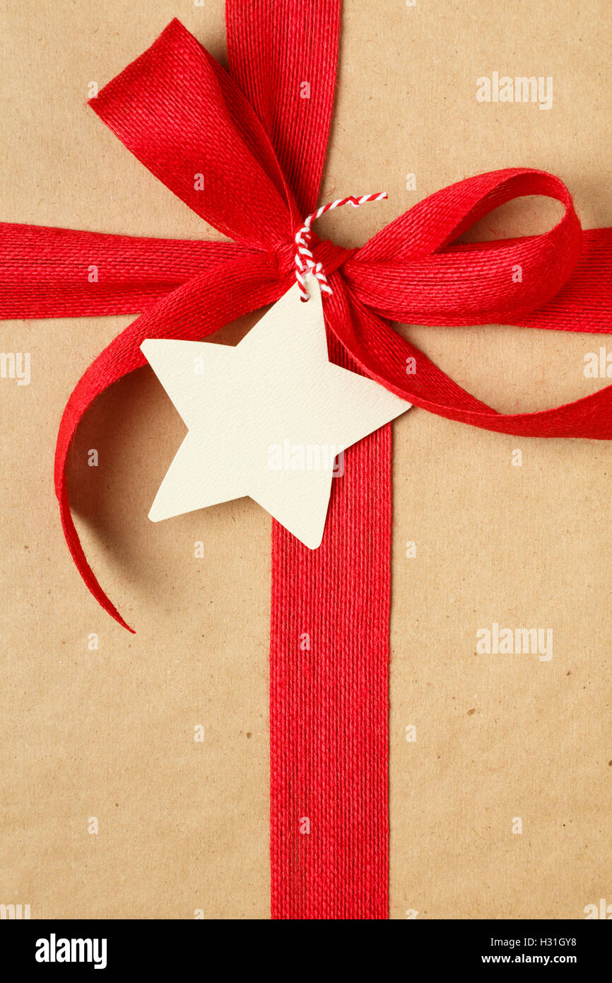 Weihnachts-Geschenk mit Schleife und leere Geschenkanhänger. Einfaches Recycling Geschenkpapier und natürliche Jute-Band. Stockfoto