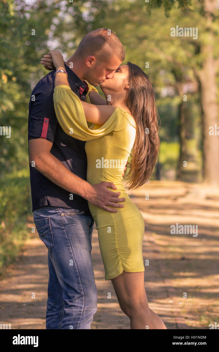 junge Erwachsene 20 s paar küssen im freien sonnigen Tagseite Profil anzeigen Stockfoto