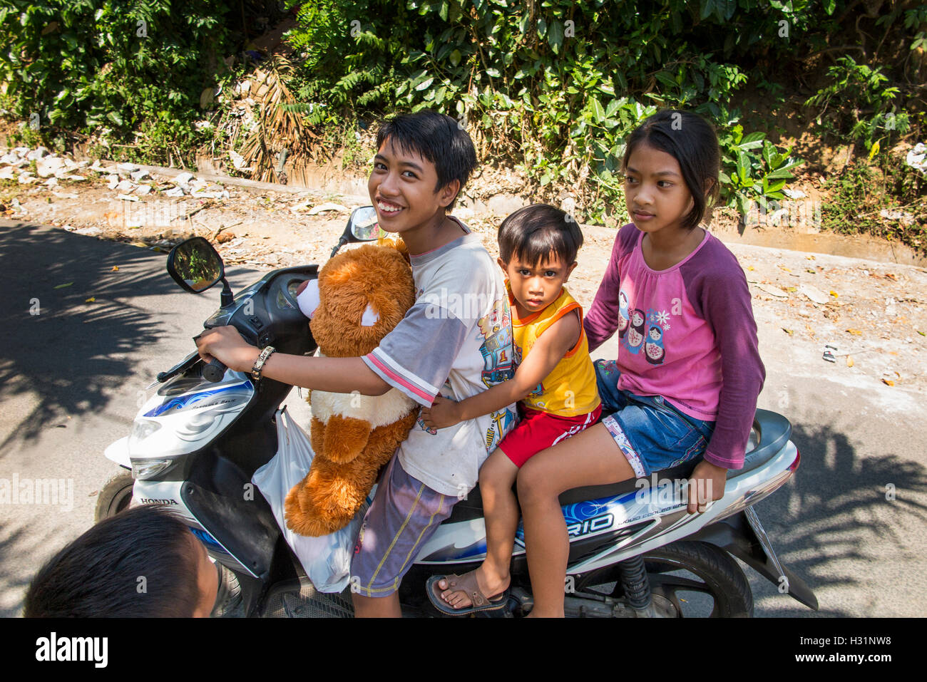 Indonesien, Bali, Lovina, Anturan Dorf drei kleine Kinder reiten auf dem Motorrad Stockfoto