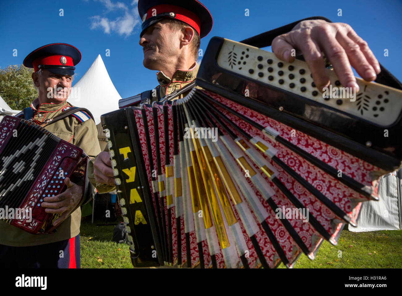 Kosaken spielen ein Knopfakkordeon während der jährlichen Festivals "Kosakensiedlung - Moskau" in Moskau Zarizyno Park, Russland Stockfoto