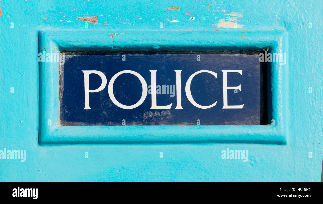 Traditionelle britische Polizei Zeichen geschrieben auf dunkelblauem Hintergrund auf einem hellen blauen hölzernen Polizei-box Stockfoto