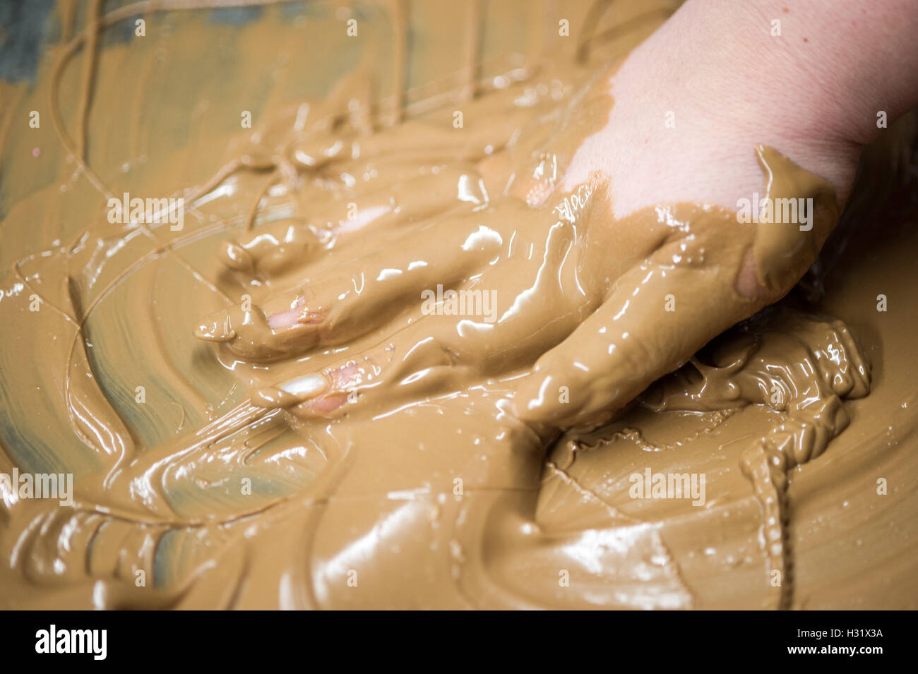 Hand in geschmolzene Schokolade bedeckt Stockfoto
