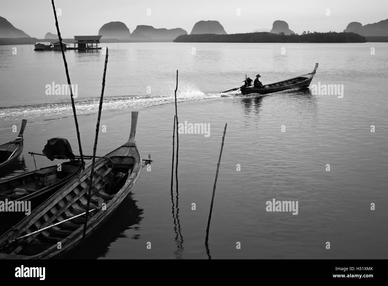 Longtail Fischerboot bei Samchong-Tai Fischerdorf am Sonnenaufgang in Phang-Nga, Thailand. Schwarz und weiß. Stockfoto