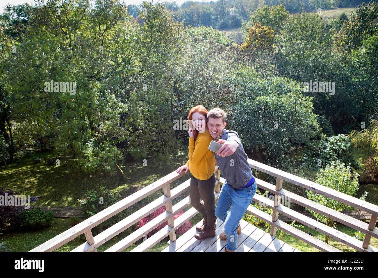 Junges Paar unter einem Selfie auf ihrem Garten Balkon mit einem Smartphone. Stockfoto