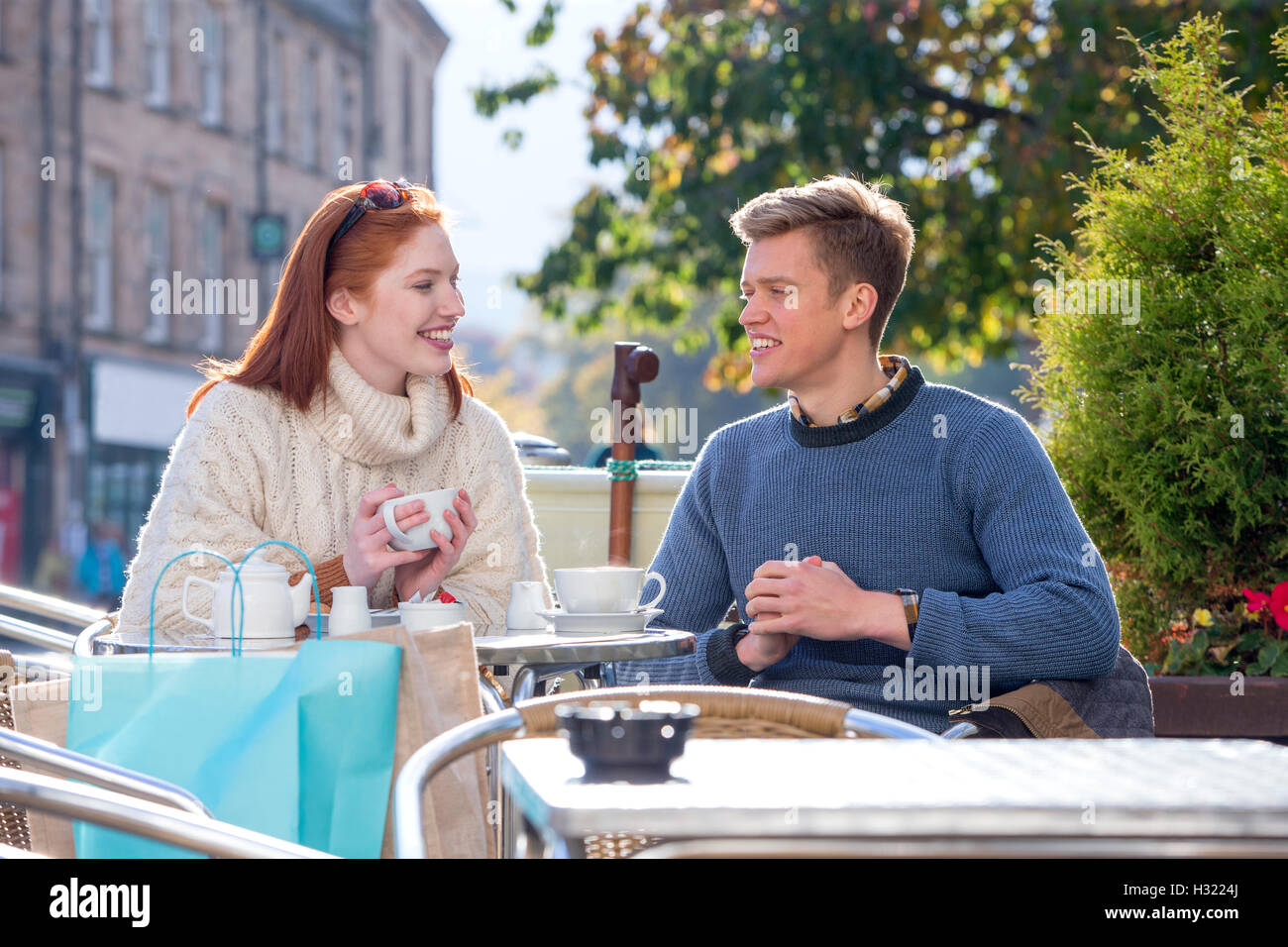 Junges Paar genießen eine Tasse Tee in einem Café zusammen. Sie sitzen im Freien in der Stadt. Stockfoto