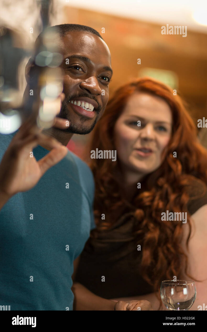 Junger Mann winken für jemanden in einer bar Stockfoto