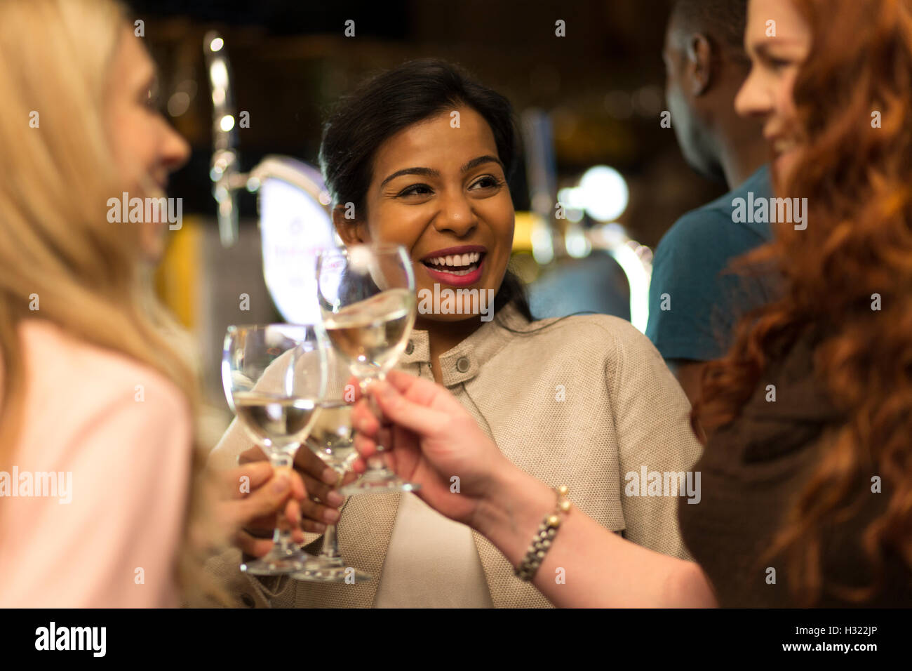 Drei Frauen, die ihre Brille in einer Bar Toasten Stockfoto