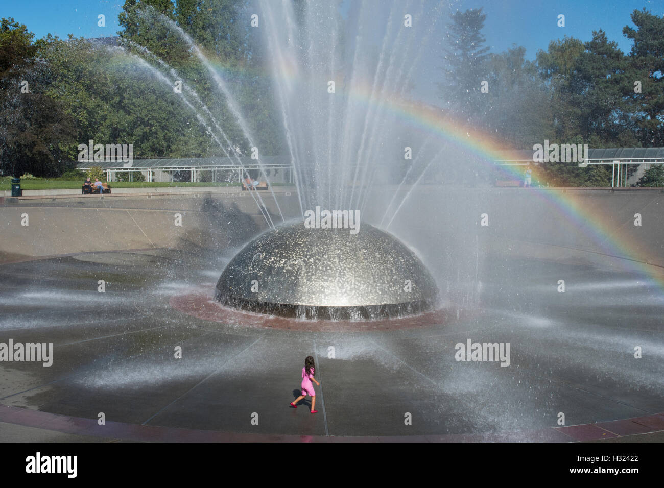 Mädchen spielt in der Gischt des International Fountain, Seattle Center, Seattle, Washington, Sommer Stockfoto