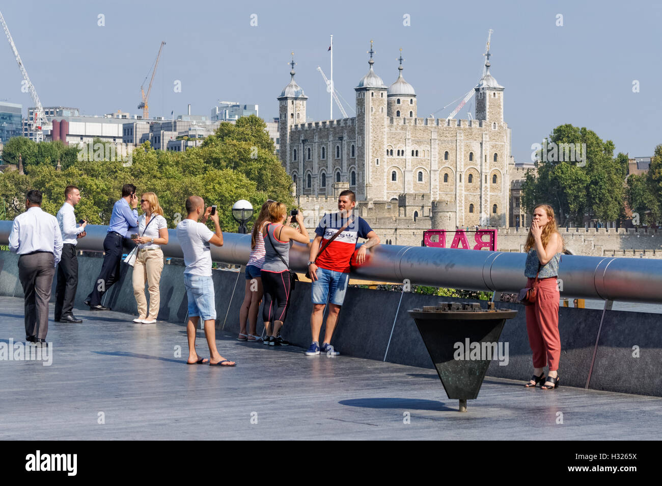 Touristen auf mehr London Riverside mit dem Tower of London im Hintergrund, London England Vereinigtes Königreich UK Stockfoto