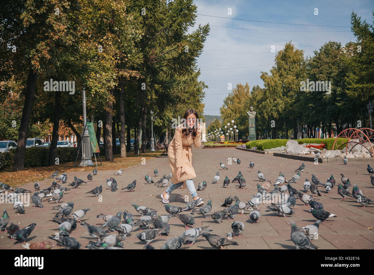 Mädchen mit Tauben in Sonnenbrille auf einer Stadt-Gasse Stockfoto