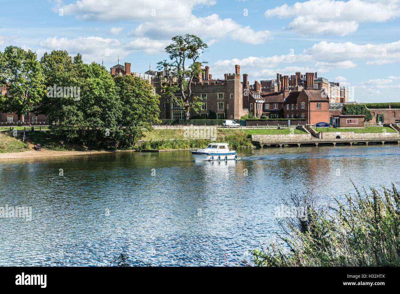 Ein kleiner Kreuzer, der vor dem Hampton Court Palace, England, Surrey, Großbritannien, vorbeifährt Stockfoto