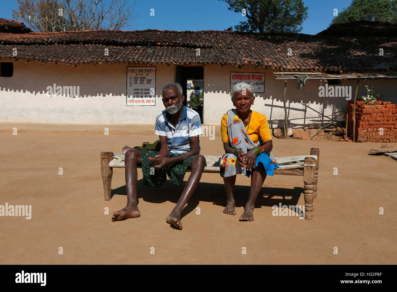 Altes Ehepaar sitzt auf einem Kinderbett, ORAON Stamm, Purkela Dorf, Taluka Lundra, Bezirk Sarguja, Chattisgarh, Indien Stockfoto