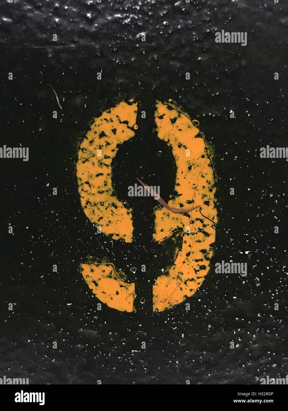 Nr. 9 in eine Schablone-Stil in der gelben Farbe orange auf den Boden gemalt Stockfoto