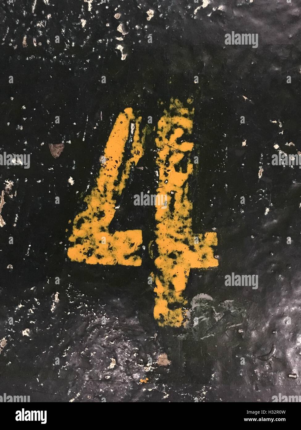 Nr. 4 in eine Schablone-Stil in der gelben Farbe orange auf den Boden gemalt Stockfoto