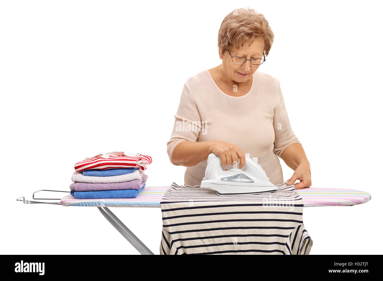 Reife Frau Bügeln von Kleidung auf dem Bügelbrett isoliert auf weißem Hintergrund Stockfoto