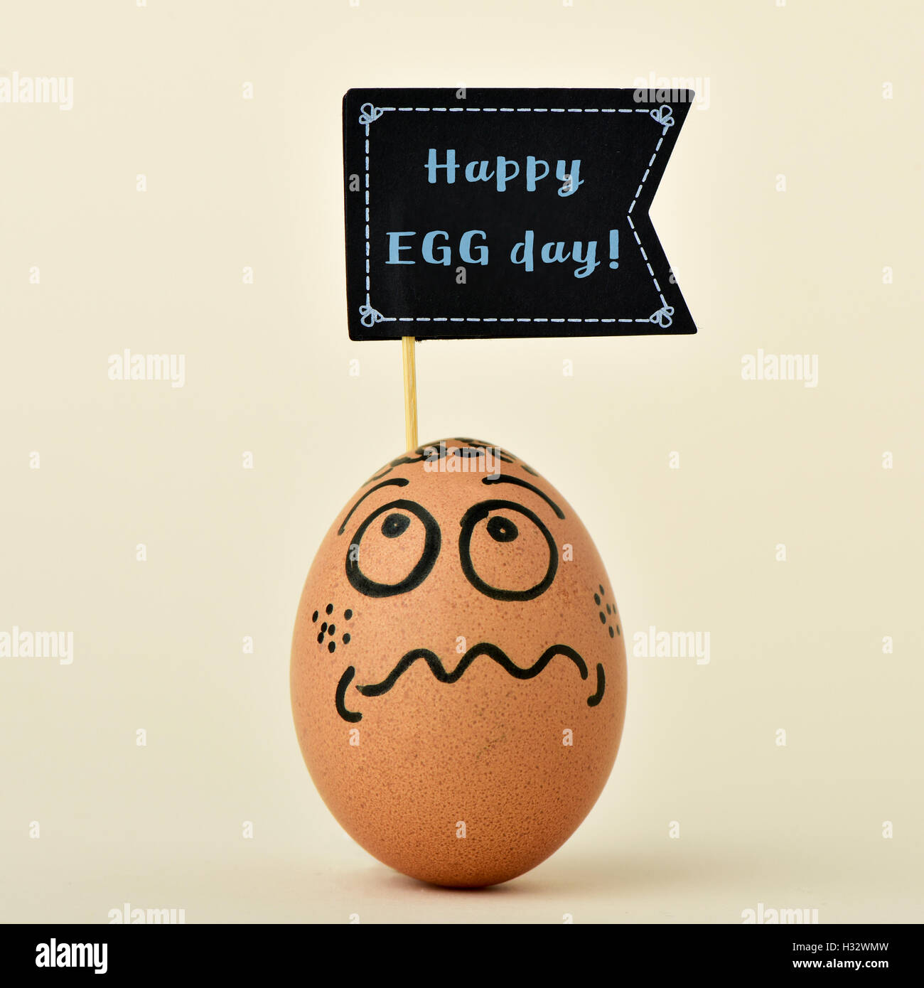 eine braune Ei mit lustigem Gesicht mit einem Black Flag-förmigen Schild mit dem Text zufrieden Ei Tag auf einen off-white background Stockfoto