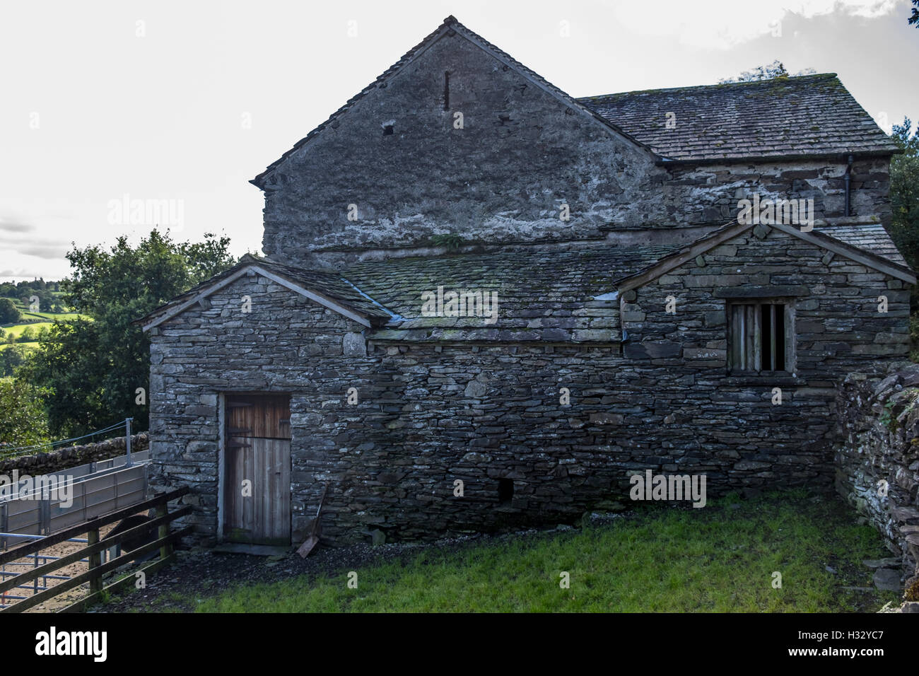 Ein sehr alter Stein Bauernhof Gebäude mit zerbrochenen Fenstern und Türen aus Holz. Stockfoto