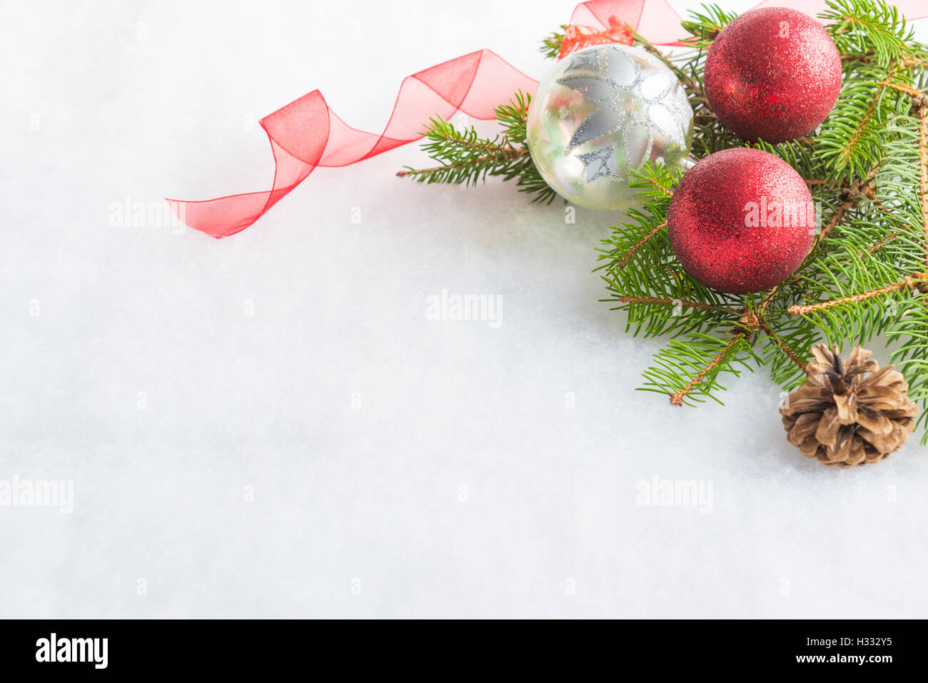 Nahaufnahme von Weihnachten rot und Glitter Kristallkugeln, Kiefer und Kegel über weiße flauschige Hintergrund. Weihnachts-Dekoration. Stockfoto